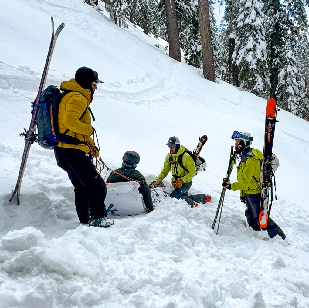 Group of skiers using mtn sense rescue tarp